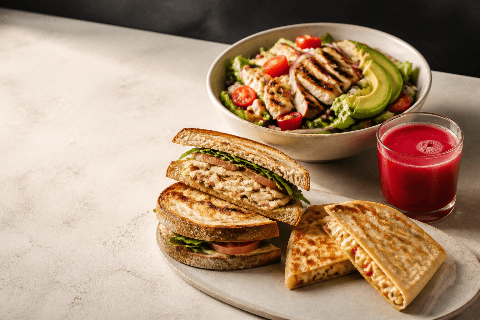 Selección de ensalada, sánduche, quesadillas y jugo fresco